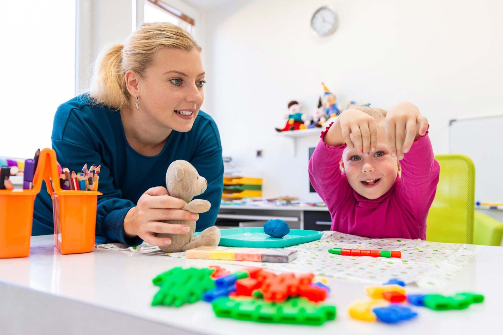A pediatric therapy session where a healthcare professional supports a child through guided play in a safe clinical environment.